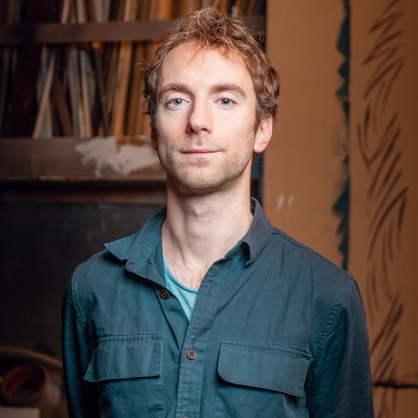 Dyan Read, a man with short blonde hair wearing a teal shirt looks seriously at camera