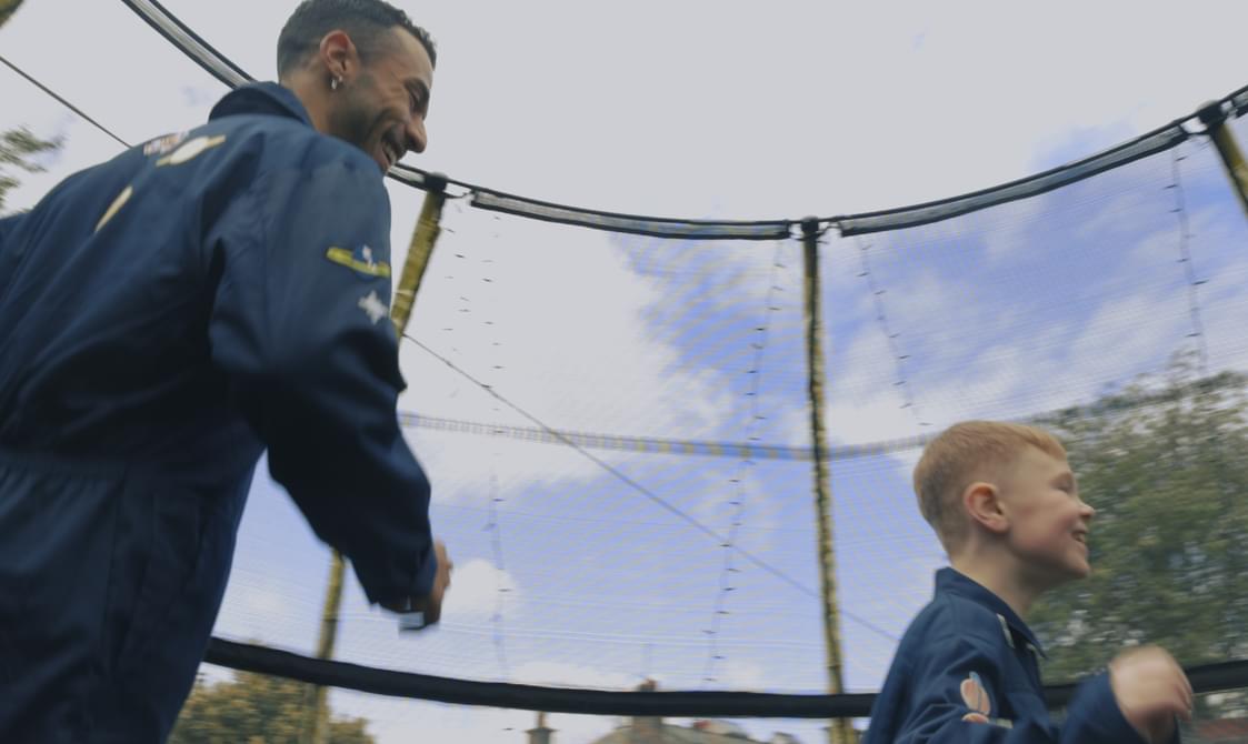 A man and a boy walk smiling on a trampoline from Every Map Has a Scale