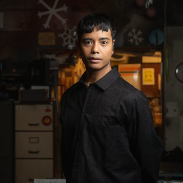 Same Vaherlehto, a person with short dark hair wearing a black shirt looks seriously at camera