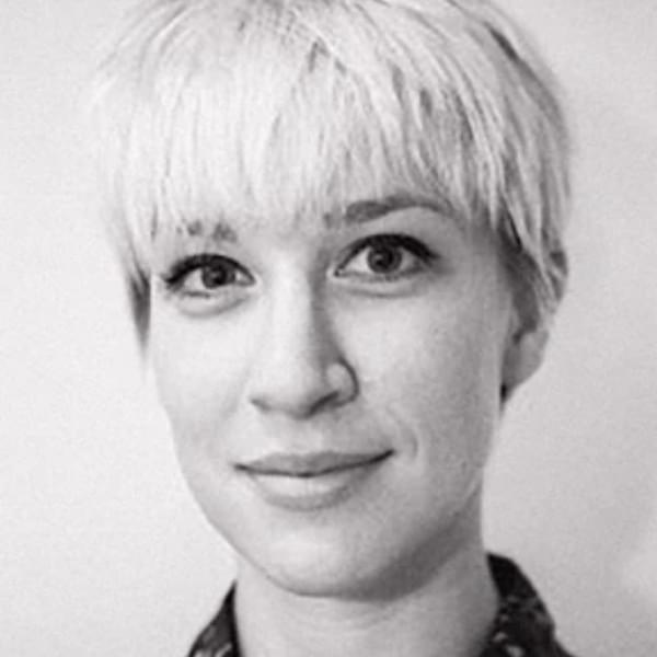Headshot of Emma Bailey, a black and white image of a woman with very short platinum blonde hair